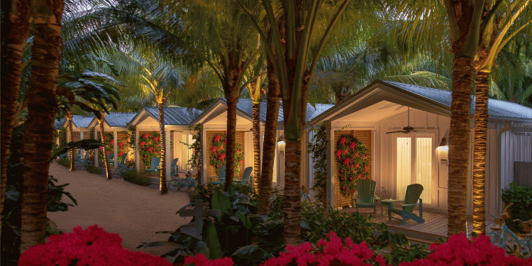 exterior image of bungalows at night with palm trees and flowers