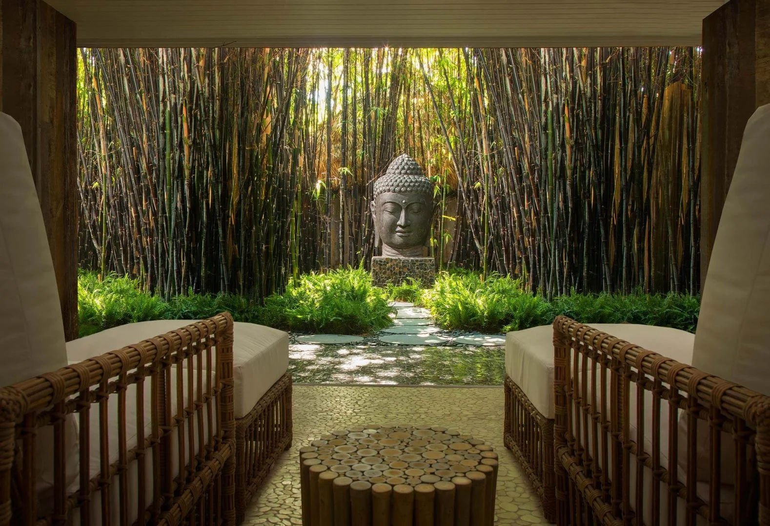 Bamboo garden with Buddha head and two chairs