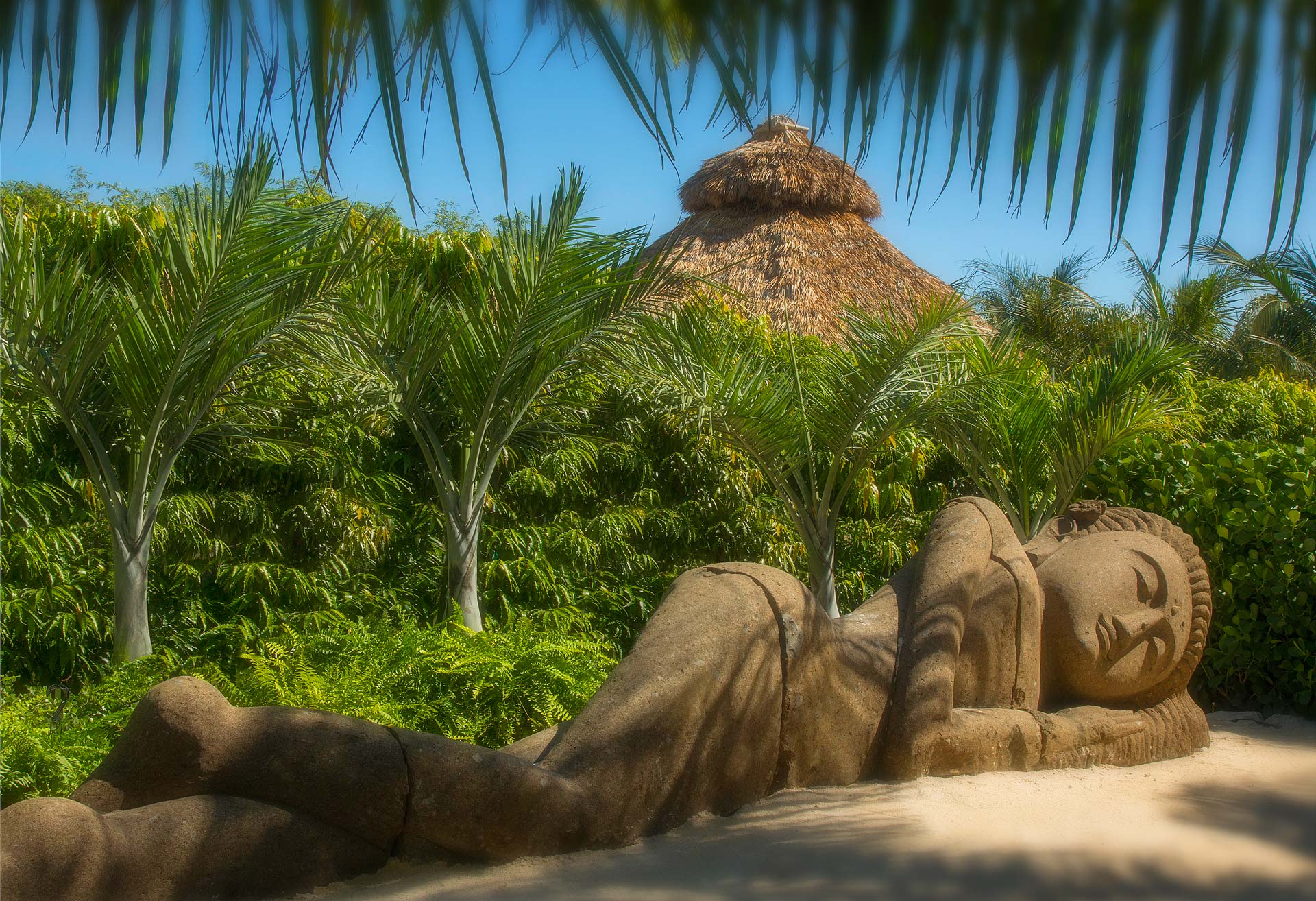 large sleeping statue on a sandy beach