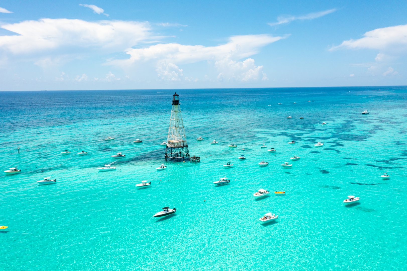 boats in the ocean with a lighthouse