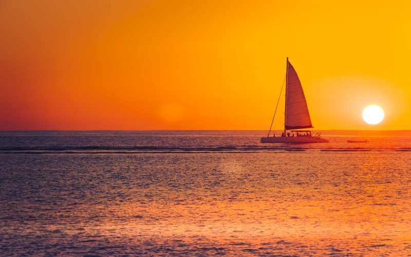 sailboat on open water at sunset